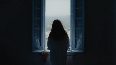 a woman standing in front of a window