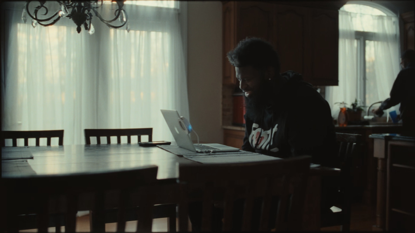 a man sitting at a table using a laptop computer