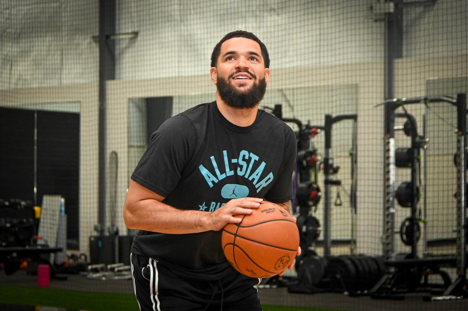 a man holding a basketball in a gym