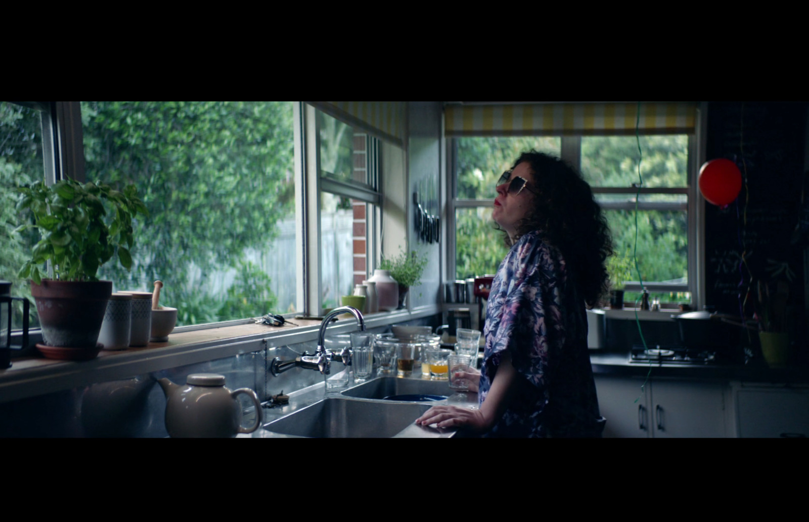 a woman standing in a kitchen next to a sink