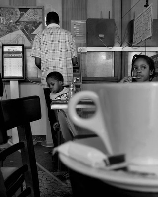 a black and white photo of people in a coffee shop