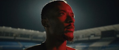 a man with a red shirt on standing in front of a stadium