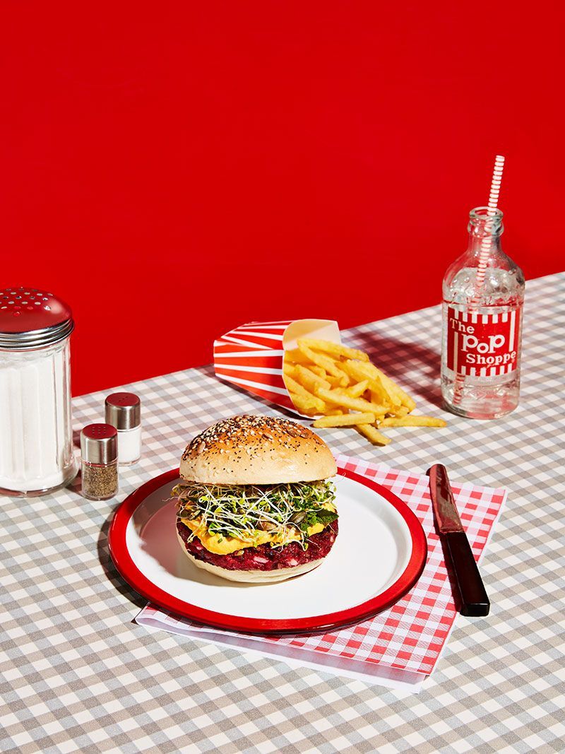 a hamburger and french fries on a red and white checkered tablecloth