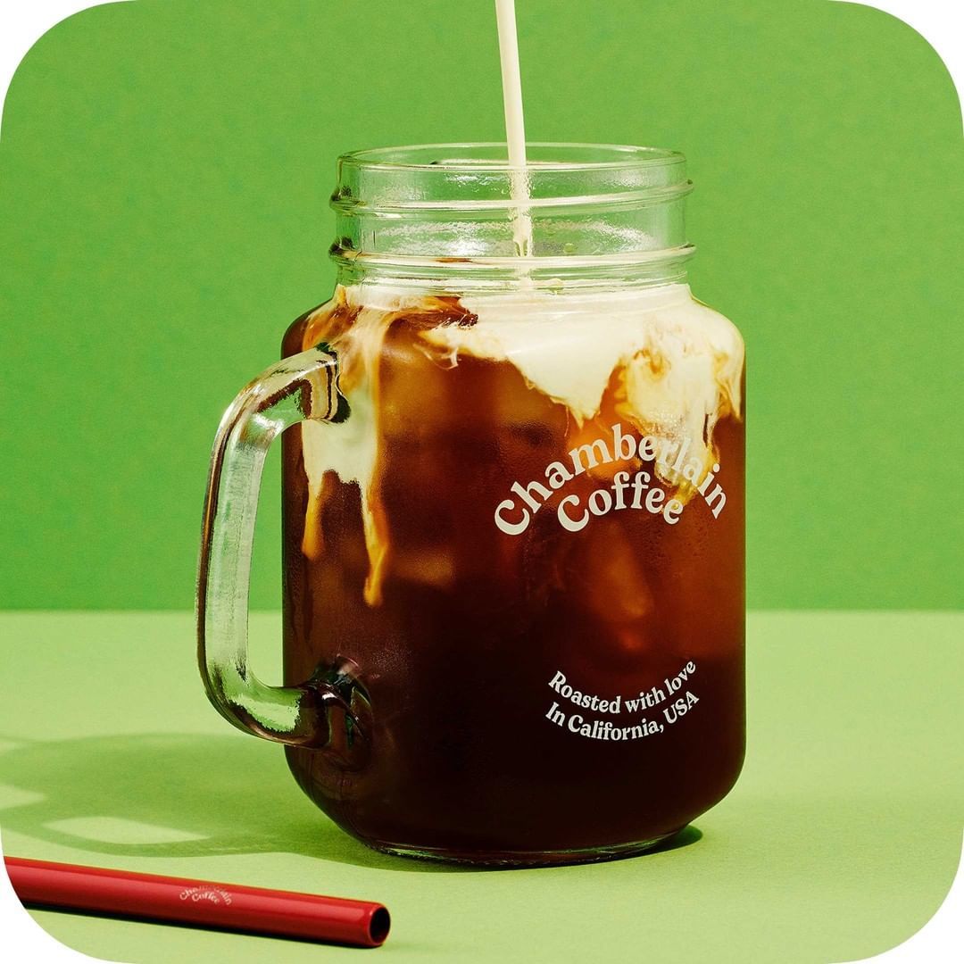 a glass of iced coffee with a straw sticking out of it