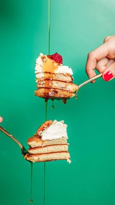 a person holding a fork with a stack of pancakes on it