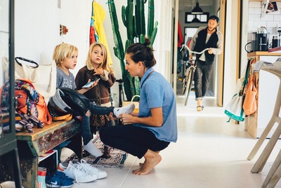 a woman sitting on a bench next to two children