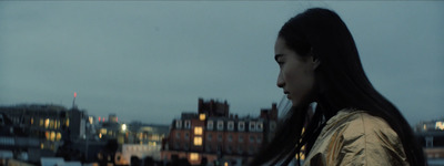 a woman with long hair standing in front of a building