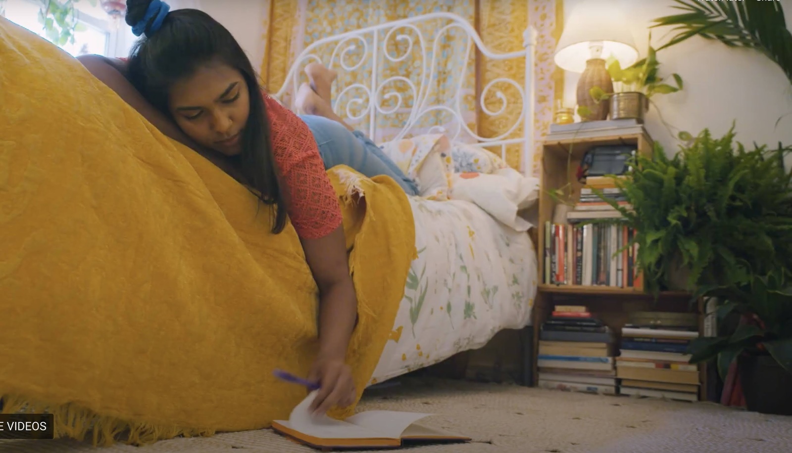 a woman laying on a bed with a yellow blanket