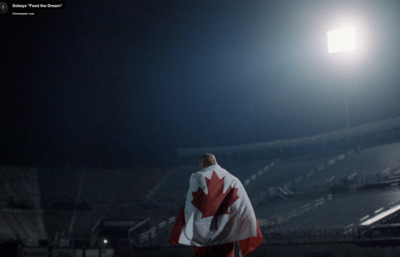 a man with a canadian flag draped over his shoulders