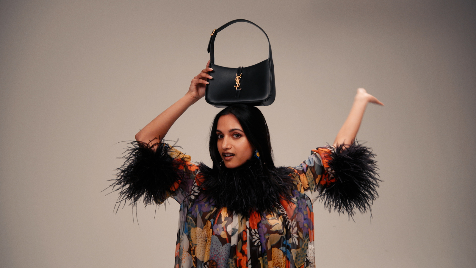 a woman holding a black purse over her head