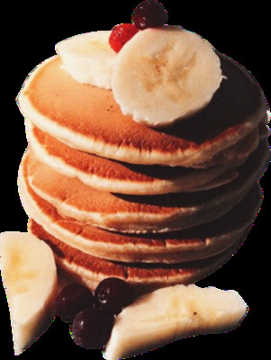 a stack of pancakes topped with bananas and cherries