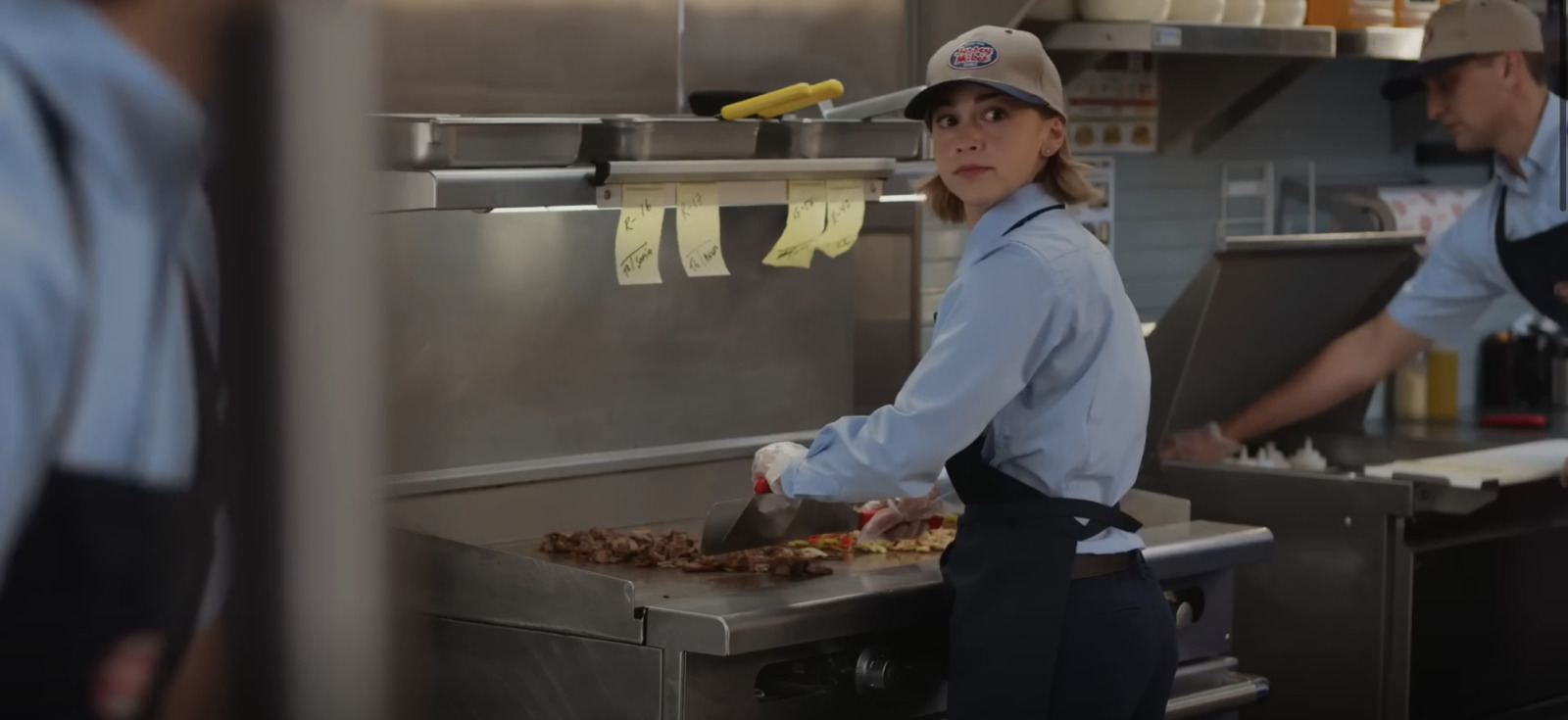 a woman standing in a kitchen preparing food