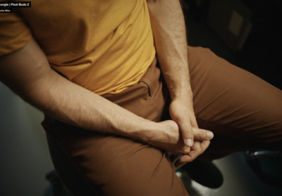 a man sitting on a toilet with his hands on his knees