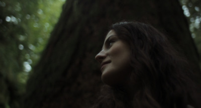 a woman standing in front of a tree