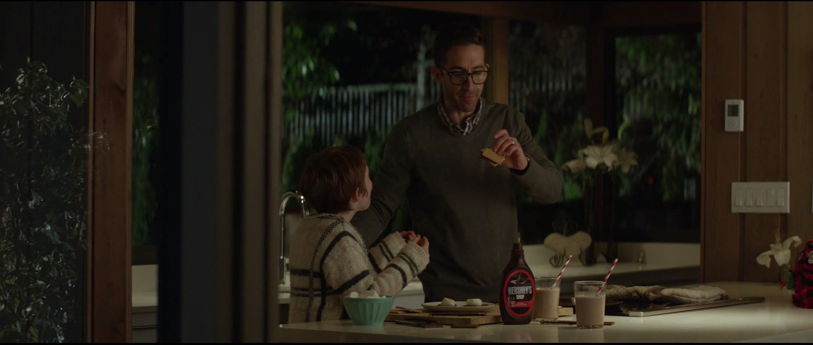 a man standing next to a little boy in a kitchen