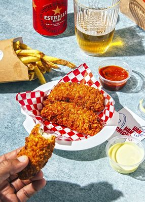 a person is holding a piece of fried food