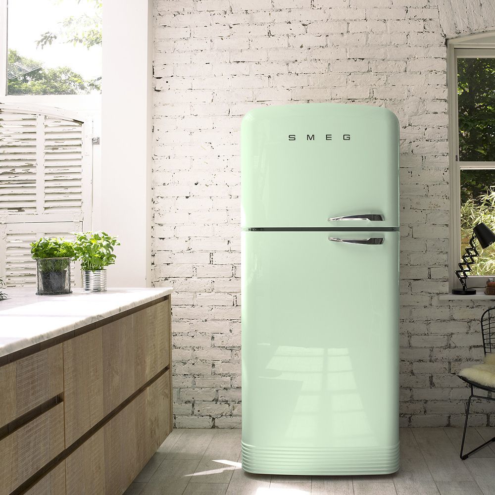 a green refrigerator sitting in a kitchen next to a window