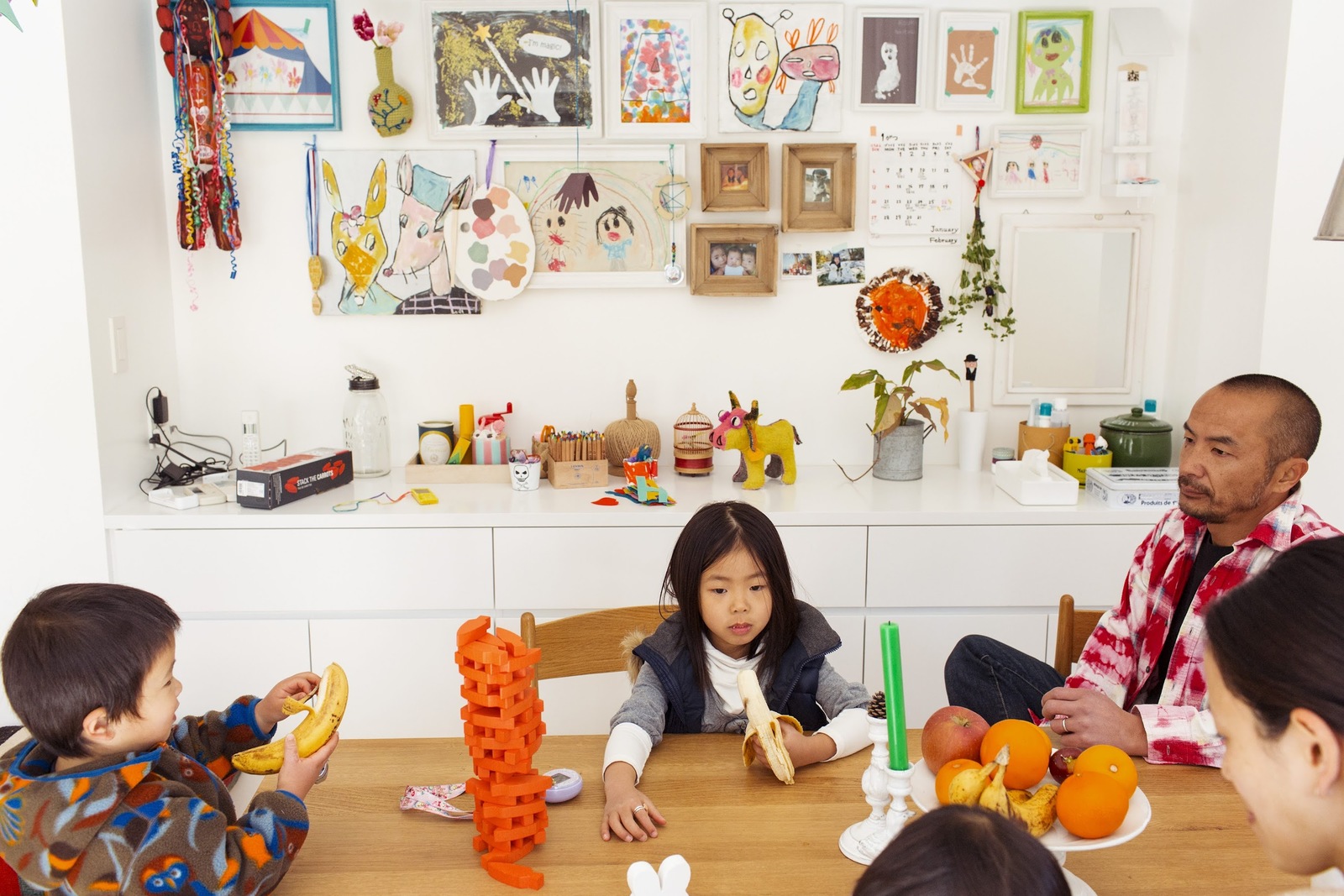 a group of children sitting around a table eating fruit