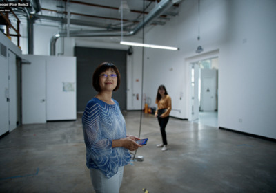 a woman standing in a room holding a remote