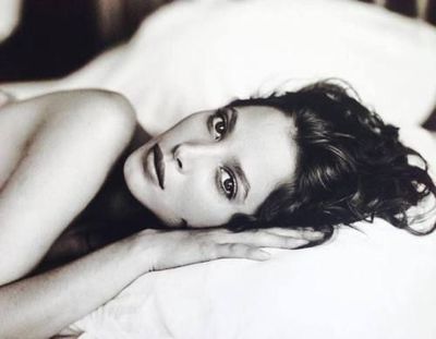 a black and white photo of a woman laying on a bed