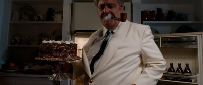 a man in a white suit smoking a pipe