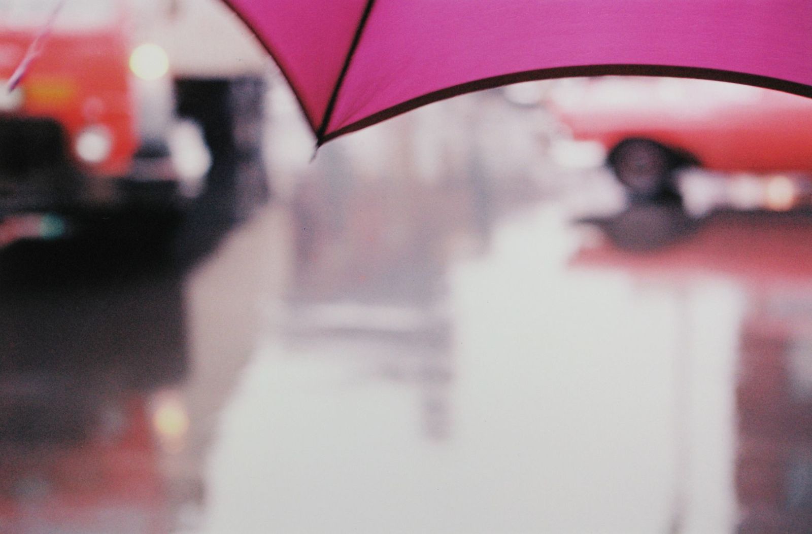 a close up of a pink umbrella on a rainy day