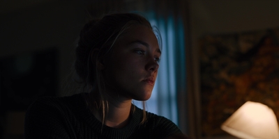 a woman sitting in front of a lamp in a dark room