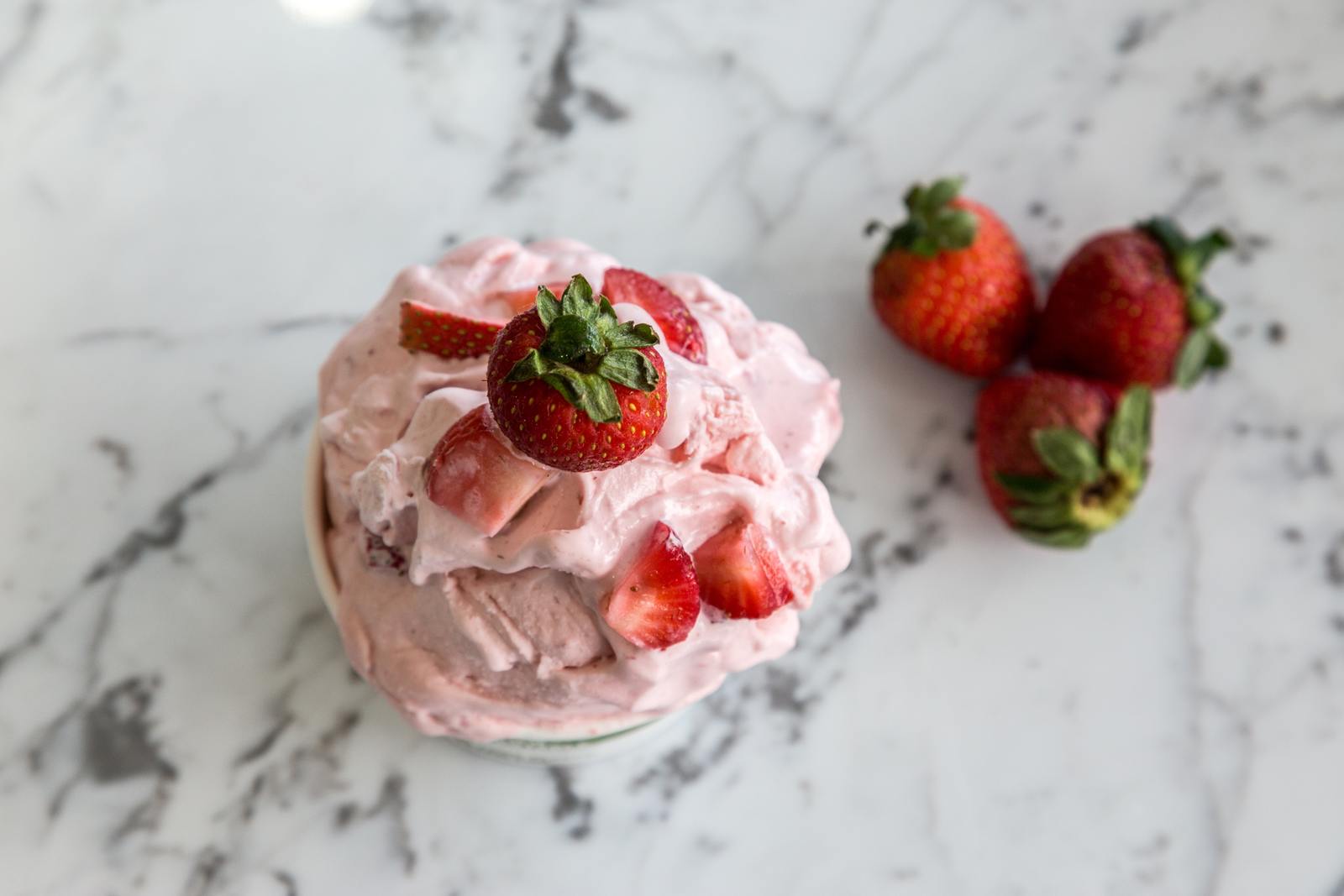 a cup of ice cream with strawberries on top