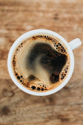 a cup of coffee on a wooden table