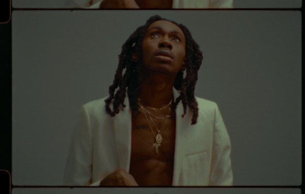 a man with dreadlocks standing in front of a mirror