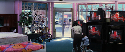 a woman and a child are looking at televisions in a store