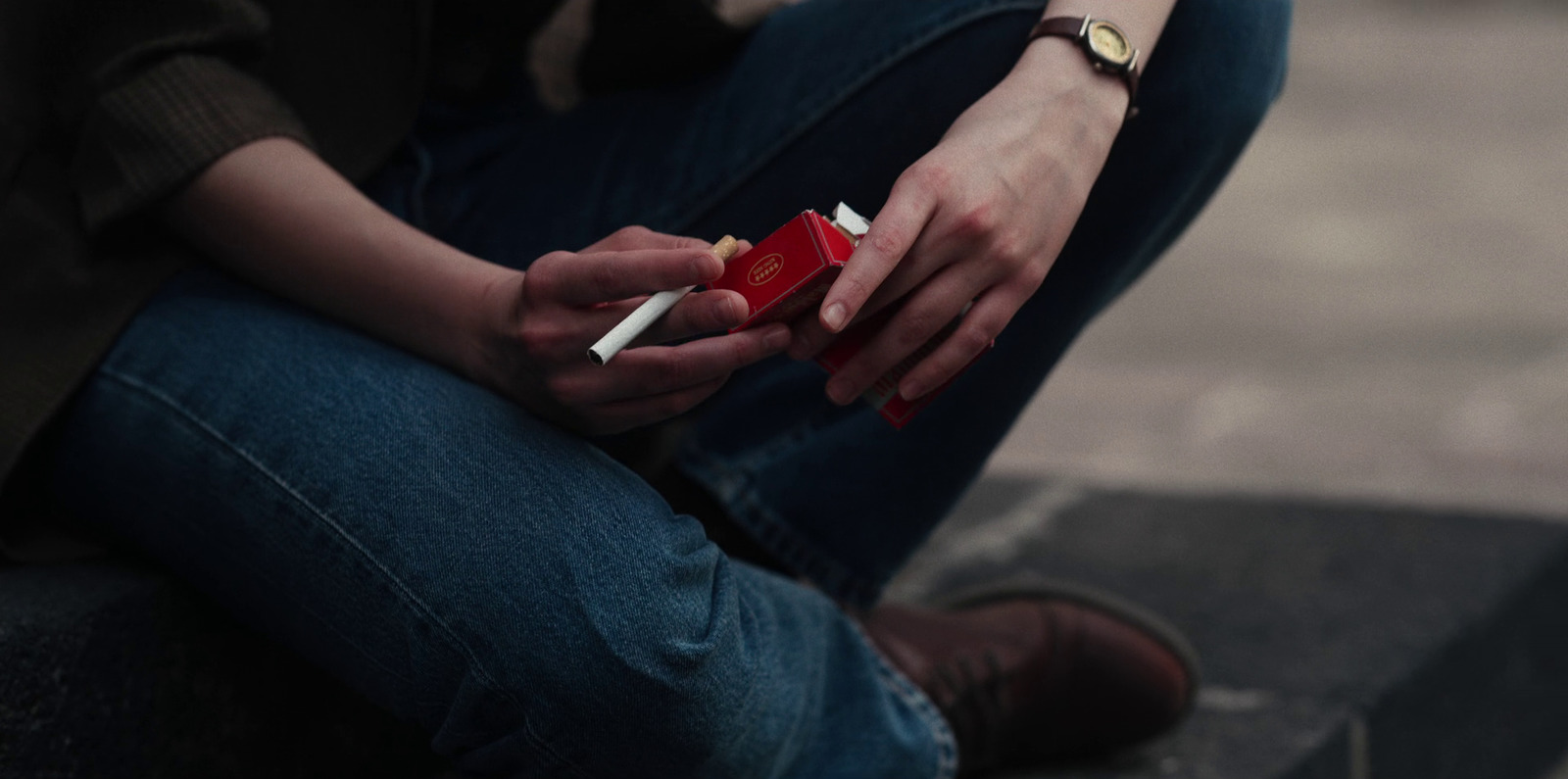 a woman sitting on a step smoking a cigarette