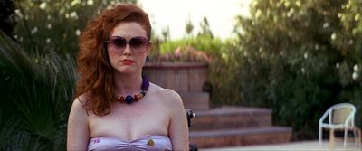 a woman with red hair wearing sunglasses and a bra