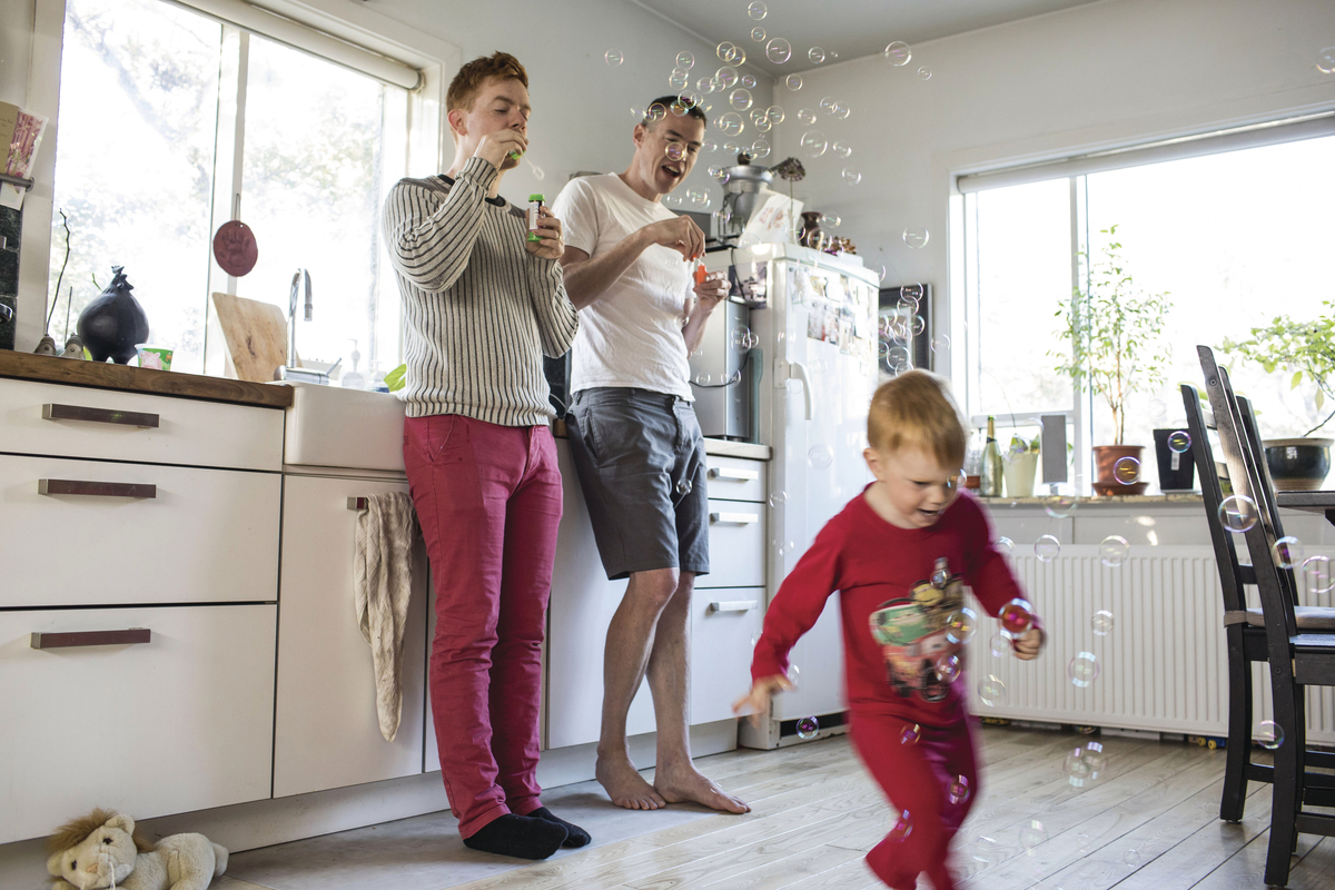 a couple of people standing in a kitchen