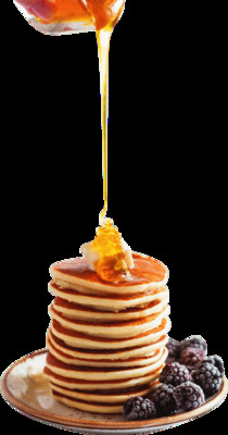 a stack of pancakes with syrup being poured on top