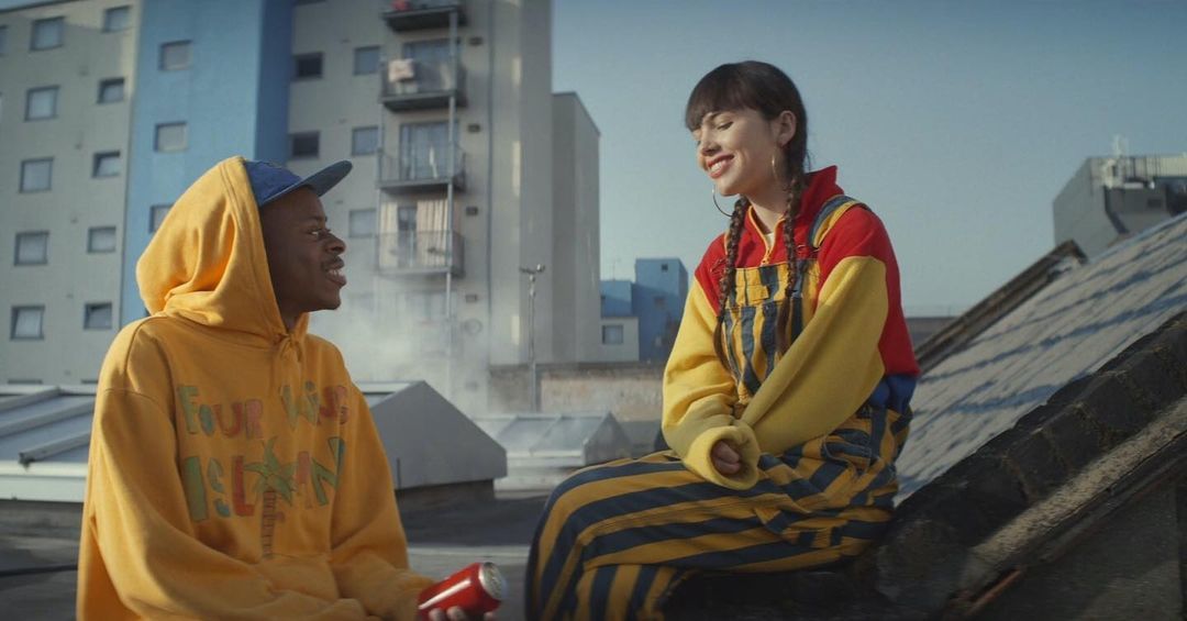 a man and a woman sitting on top of a roof