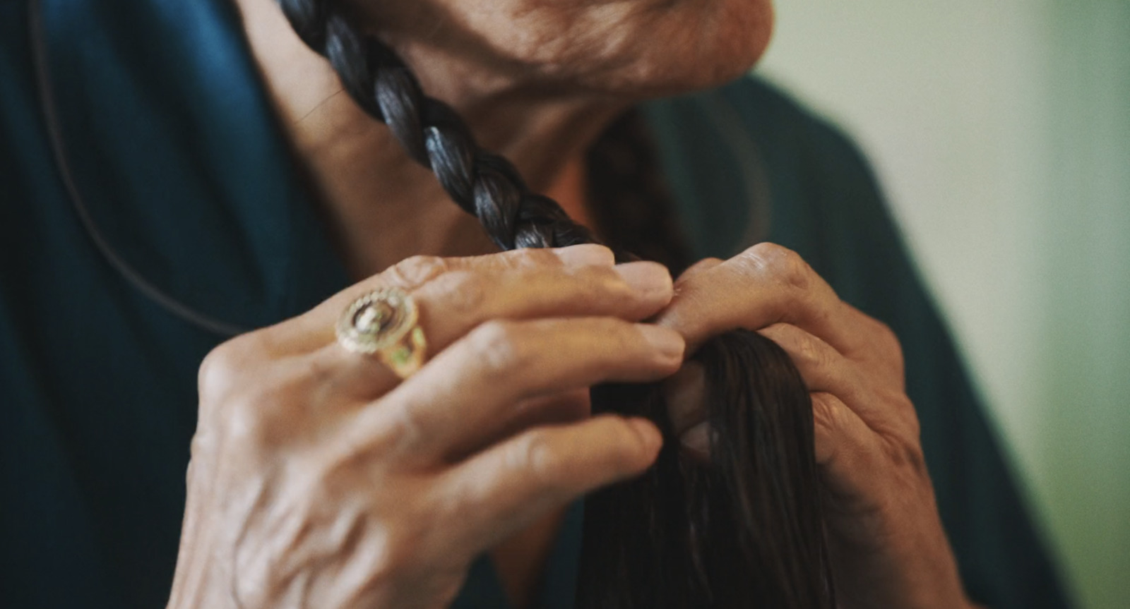 a woman is braiding her hair with a ring