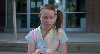 a woman sitting on the steps with a cell phone in her hand