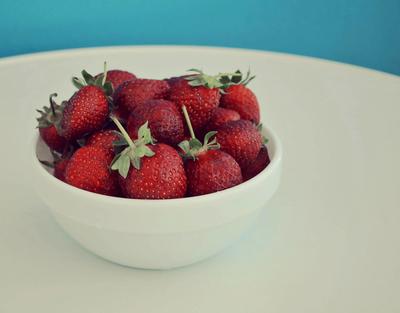 a bowl of strawberries on a white table