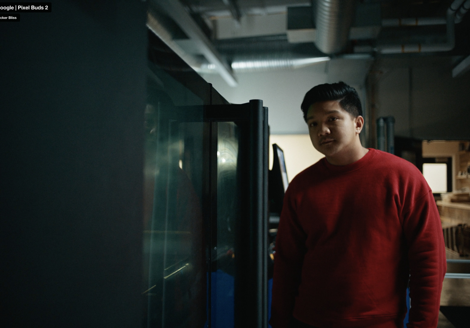 a man in a red sweater standing next to a refrigerator