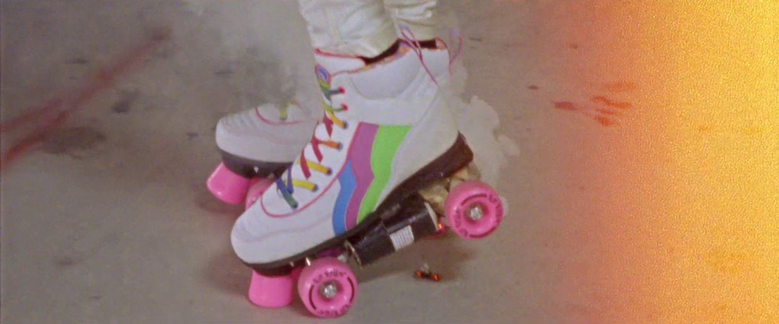 a person riding a skateboard with pink wheels