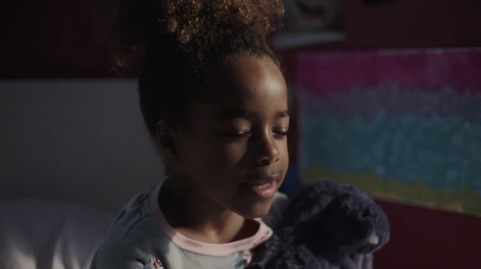 a young girl holding a teddy bear in her hands