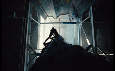 a man climbing up the side of a climbing wall