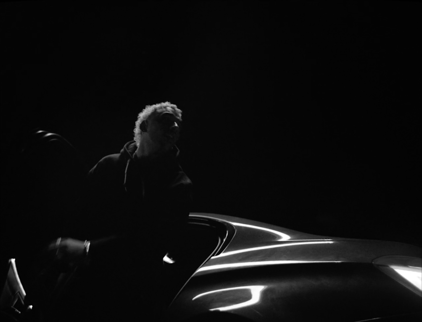 a man standing next to a car in the dark