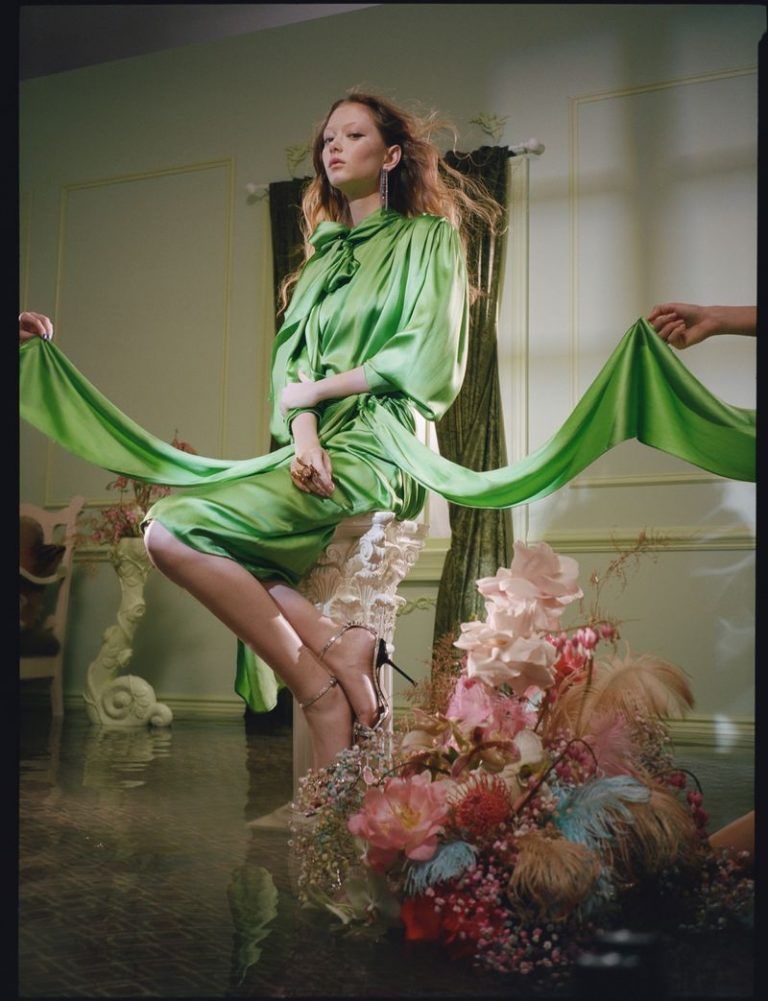 a woman in a green dress is posing for a picture