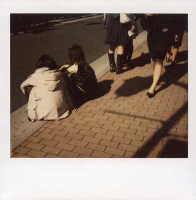 a group of people sitting on the side of a road