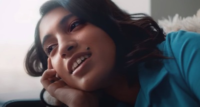 a woman laying down with her chin resting on her hand