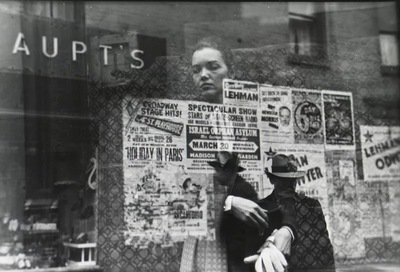 a man holding up a sign in front of a store