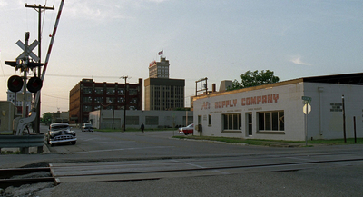 an empty street with a traffic light and a building in the background