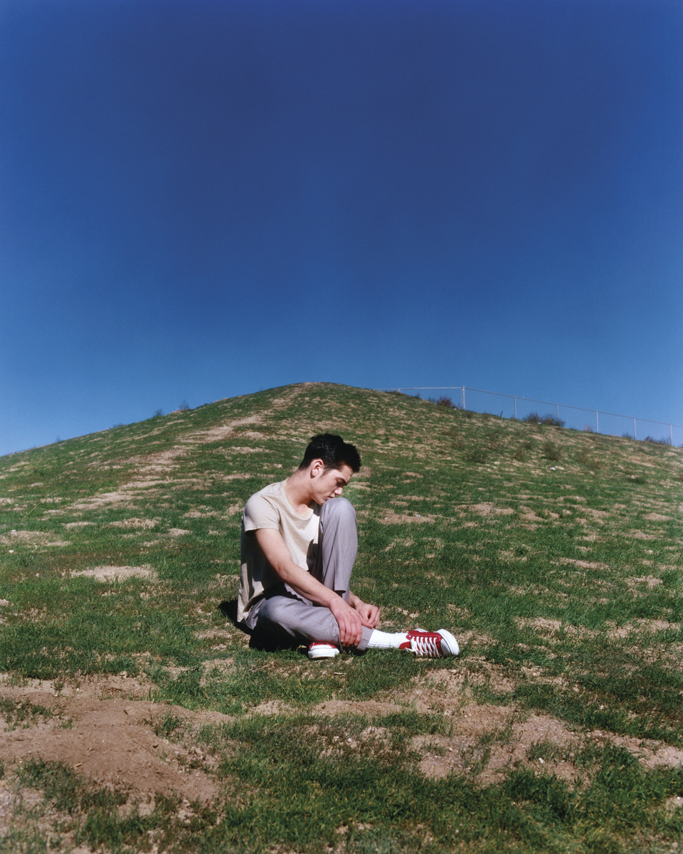 a man sitting on the ground with a bottle in his hand